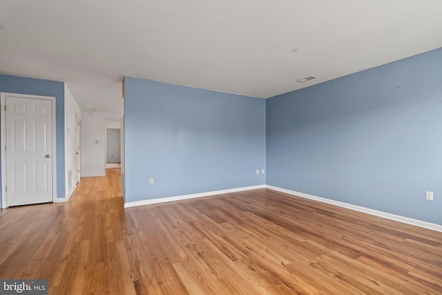 unfurnished room with baseboards, visible vents, and light wood finished floors