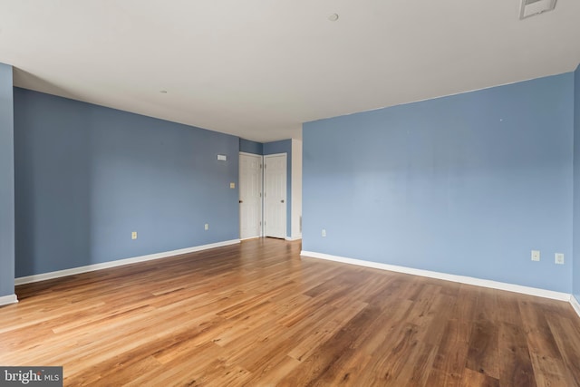 unfurnished room with visible vents, baseboards, and wood finished floors