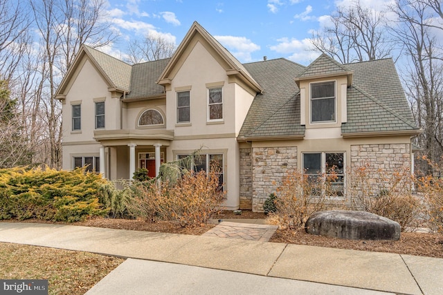 view of front of property featuring stone siding and stucco siding