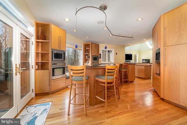 kitchen with a kitchen island, appliances with stainless steel finishes, a kitchen breakfast bar, french doors, and open shelves