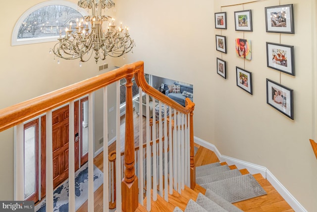 stairs with visible vents, baseboards, and wood finished floors