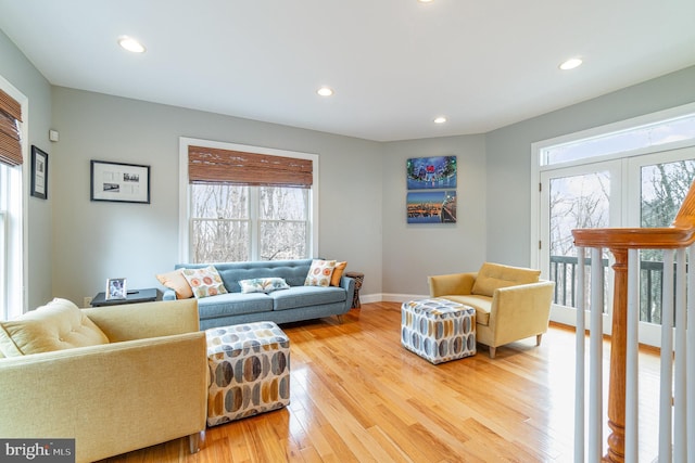 living area with baseboards, light wood-style flooring, and recessed lighting