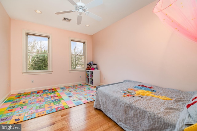 bedroom with recessed lighting, wood finished floors, visible vents, and baseboards