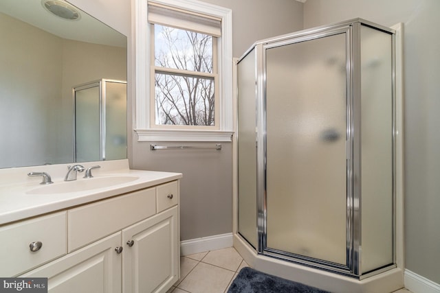 bathroom featuring a stall shower, tile patterned flooring, vanity, and baseboards