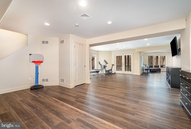 workout area featuring wood finished floors, visible vents, and baseboards