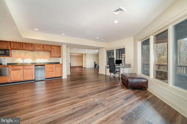 kitchen featuring visible vents, dishwasher, open floor plan, black microwave, and a sink