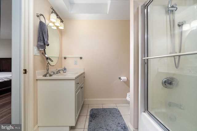 full bath featuring shower / bath combination with glass door, toilet, vanity, tile patterned flooring, and baseboards