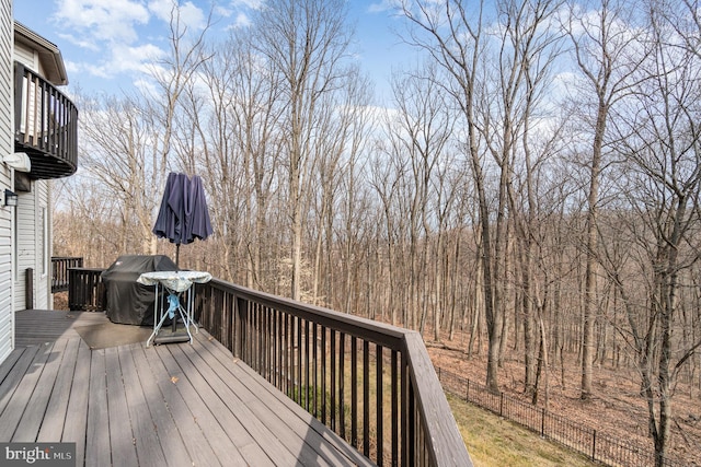 wooden deck with a grill and fence