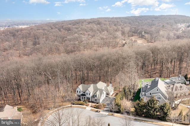 drone / aerial view with a wooded view