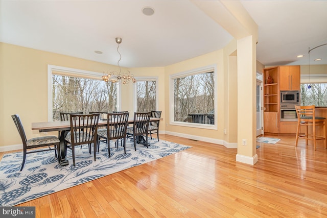 dining space featuring light wood finished floors, baseboards, a chandelier, and recessed lighting