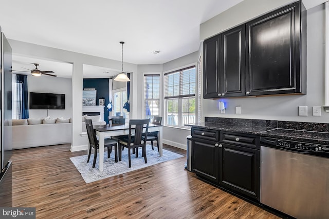 kitchen featuring ceiling fan, open floor plan, stainless steel dishwasher, dark cabinetry, and dark wood-style flooring