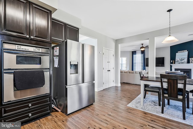 kitchen featuring light wood-type flooring, dark brown cabinetry, appliances with stainless steel finishes, and ceiling fan