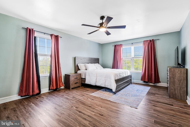 bedroom featuring baseboards, wood finished floors, and a ceiling fan