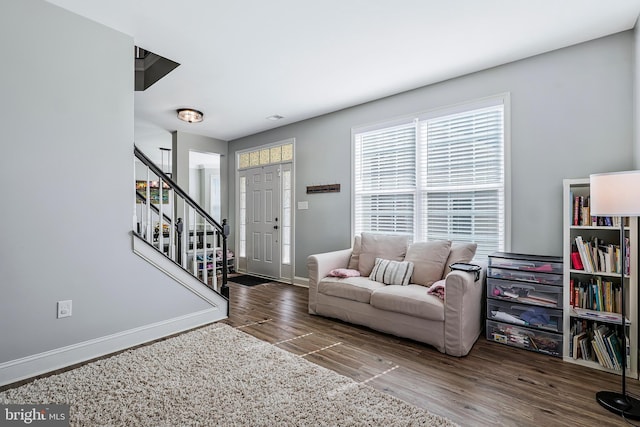 living room with stairway, baseboards, and wood finished floors