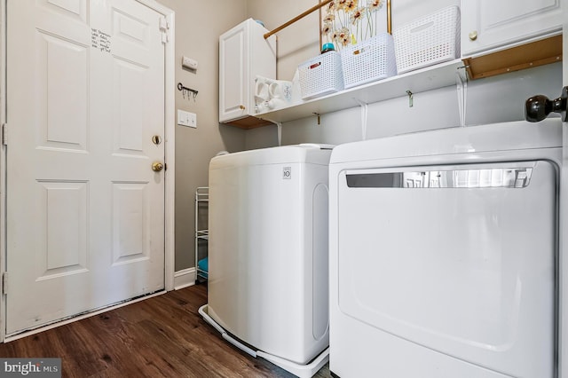 clothes washing area with cabinet space, dark wood-type flooring, and washing machine and dryer