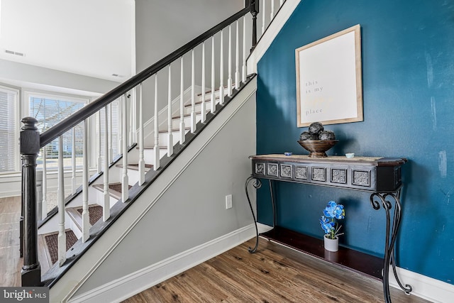 stairs featuring visible vents, baseboards, and wood finished floors