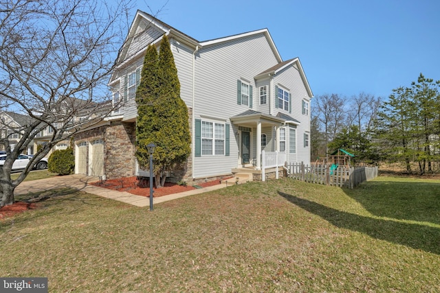 traditional home with stone siding, driveway, a front lawn, and a playground