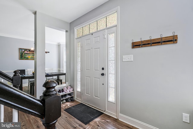 entrance foyer featuring baseboards, wood finished floors, and ornamental molding