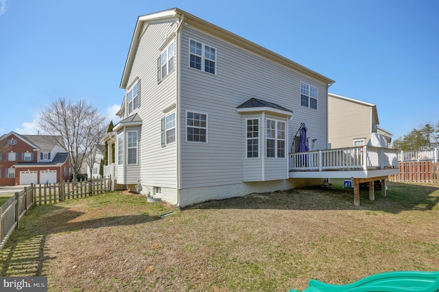 back of property featuring a deck, a yard, and fence