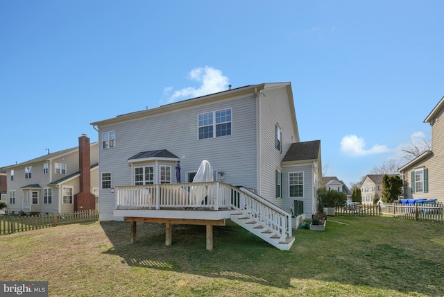 back of property featuring fence private yard, a lawn, and a wooden deck