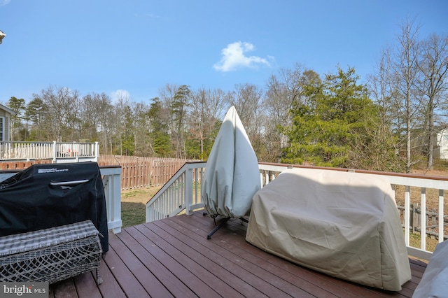 wooden deck with area for grilling and fence