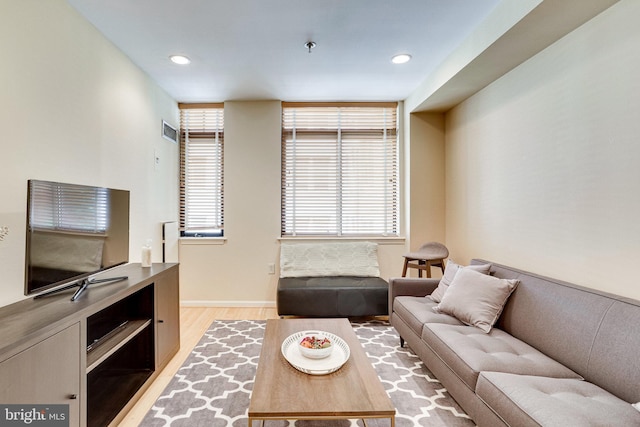 living area with recessed lighting, light wood-type flooring, a healthy amount of sunlight, and visible vents