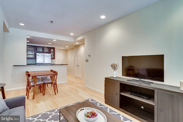 living room featuring light wood-style flooring, recessed lighting, and baseboards