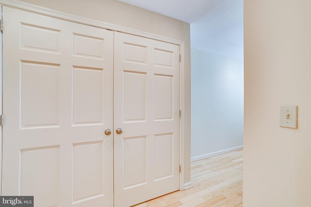 hallway with baseboards and light wood-style flooring