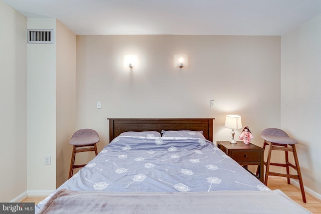 bedroom with visible vents, baseboards, and wood finished floors