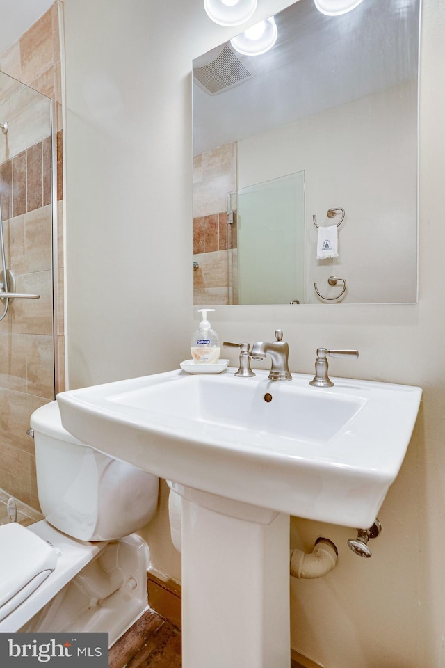 full bath featuring toilet and a tile shower