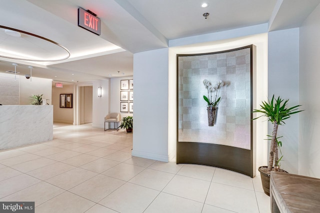 interior space with light tile patterned flooring, recessed lighting, and a raised ceiling