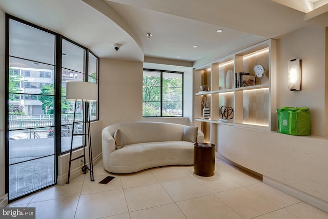 living area featuring light tile patterned floors, baseboards, and recessed lighting