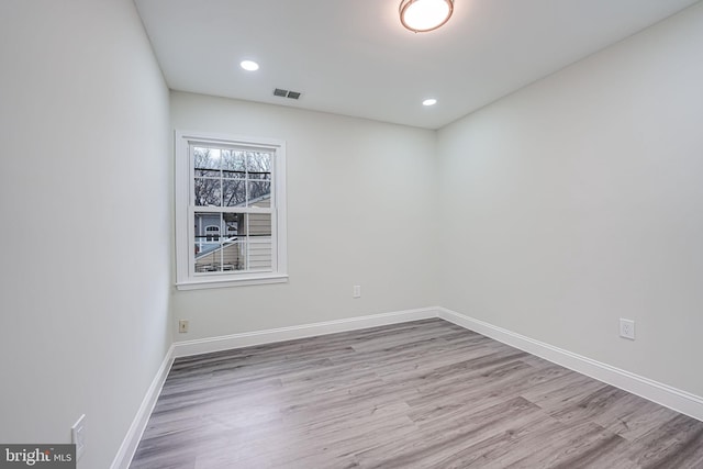 empty room with baseboards, visible vents, wood finished floors, and recessed lighting