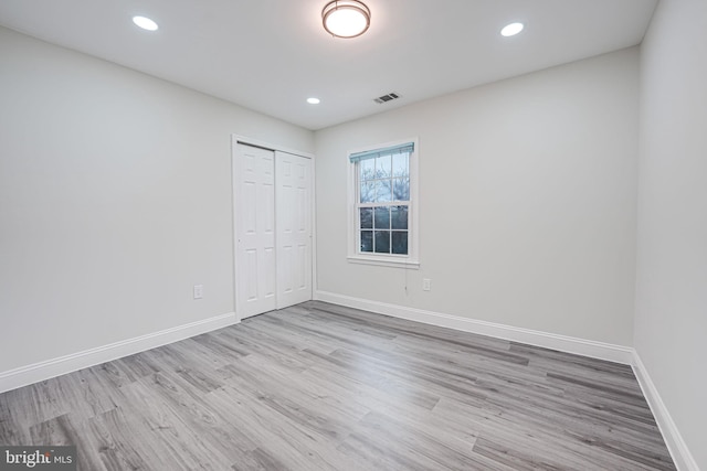 unfurnished bedroom featuring recessed lighting, wood finished floors, visible vents, and baseboards