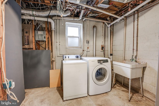 clothes washing area featuring laundry area, washer and clothes dryer, a sink, and electric panel