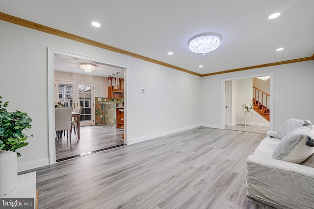 living area featuring light wood-style flooring, baseboards, and a notable chandelier