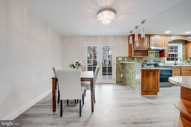 kitchen with french doors, stainless steel electric stove, light wood-style floors, a sink, and under cabinet range hood