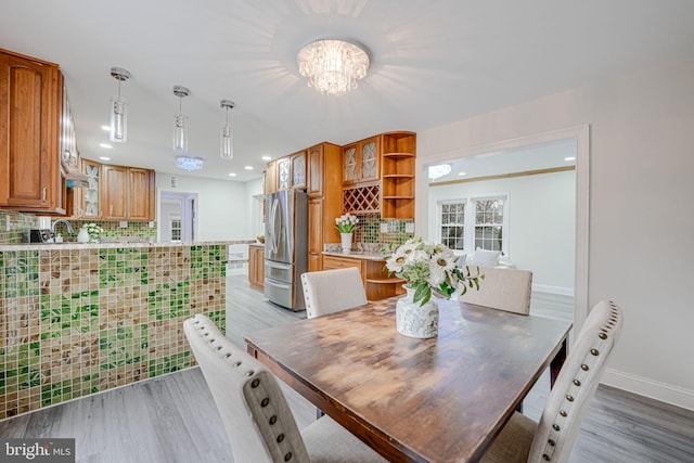 dining area with recessed lighting, baseboards, a notable chandelier, and light wood finished floors