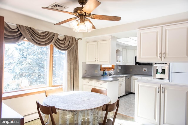 kitchen with a baseboard heating unit, light tile patterned floors, appliances with stainless steel finishes, white cabinets, and open shelves