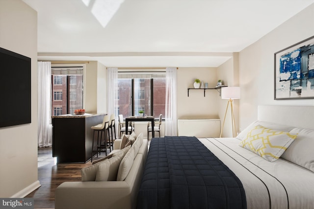 bedroom featuring multiple windows, wood finished floors, and baseboards