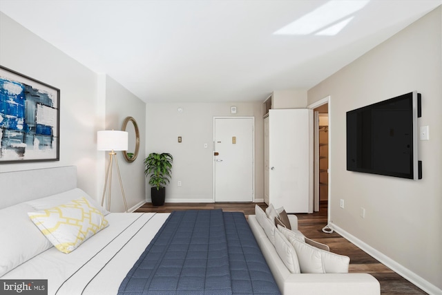 bedroom with baseboards and wood finished floors