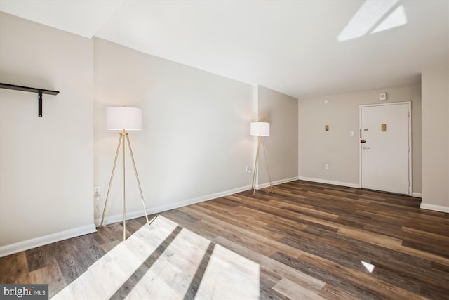 spare room featuring wood finished floors and baseboards