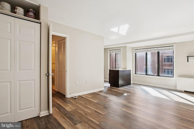 interior space featuring baseboards and dark wood-style flooring