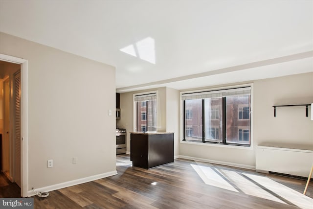 interior space with a skylight, baseboards, and dark wood-type flooring