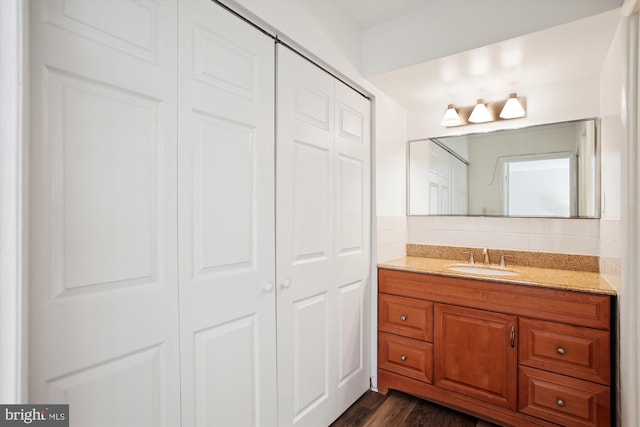 bathroom with tasteful backsplash, wood finished floors, a closet, and vanity