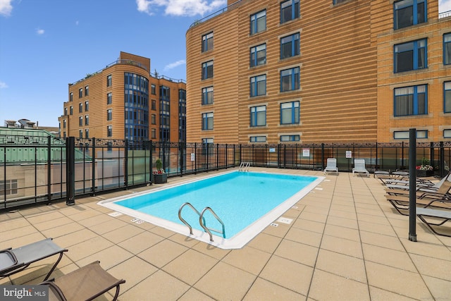 view of pool featuring fence and a patio