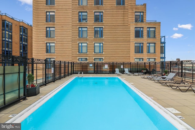 view of swimming pool with fence and a patio