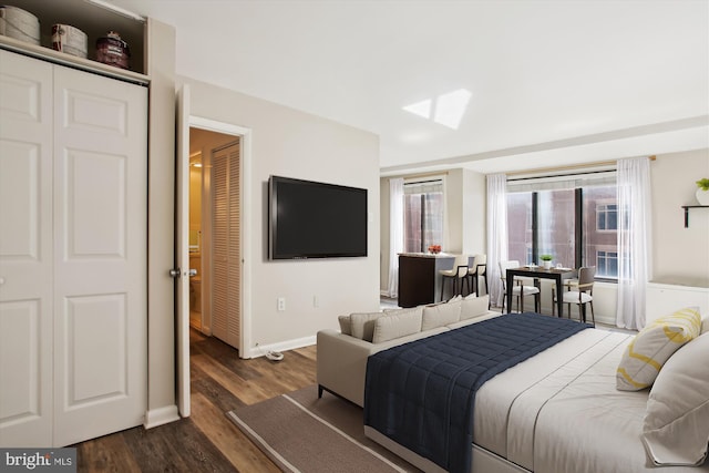 bedroom with dark wood-type flooring and baseboards