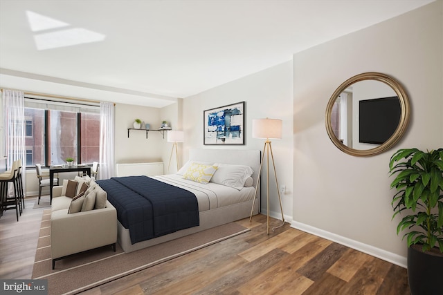 bedroom featuring wood finished floors and baseboards