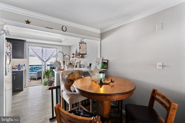 dining space featuring ornamental molding and light wood finished floors